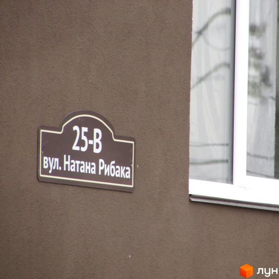 Будинок житлового комплексу Парковий з адресою вул. Натана Рибака, 25-В. Фасад будинку коричневого кольору, поруч розташоване вікно.