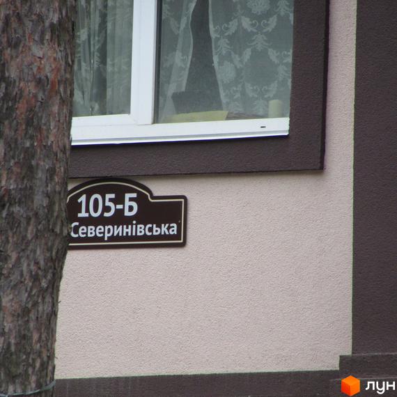 Будинок ЖК Парковий, адреса Северінівська, 105-Б. Зовнішній вигляд фасаду будівлі з вікном та табличкою адреси.