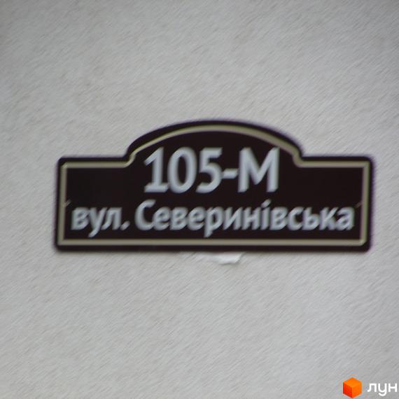Будинок №105-М по вулиці Северинівська. Зовнішній вигляд будівлі та табличка з адресою.