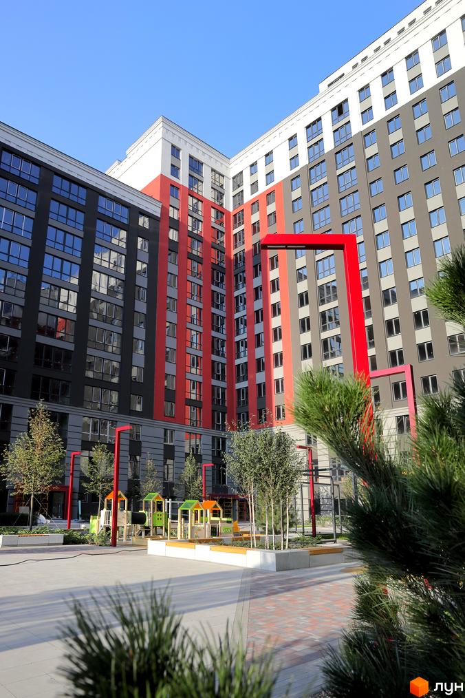 Зовнішній вигляд багатоповерхового будинку в Житловому комплексі Irpin City. На території є дитячий майданчик та зелені насадження.