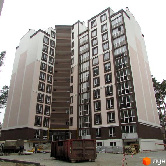 Новобудова ЖК Парковий з великою кількістю вікон та балконів. На прибудинковій території видно будівельне сміття та транспорт.