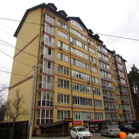 Житловий комплекс Полтавський двір. Багатоповерховий будинок з великою кількістю вікон та балконів. На першому поверсі розташовані комерційні приміщення, перед будинком припарковані автомобілі.