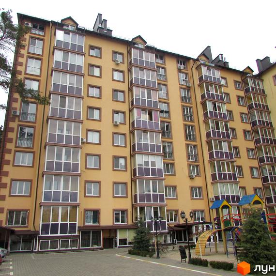 Висотна будівля ЖК Полтавський двір з великими вікнами та балконами. На прибудинковій території облаштовано дитячий майданчик та висаджено дерева.