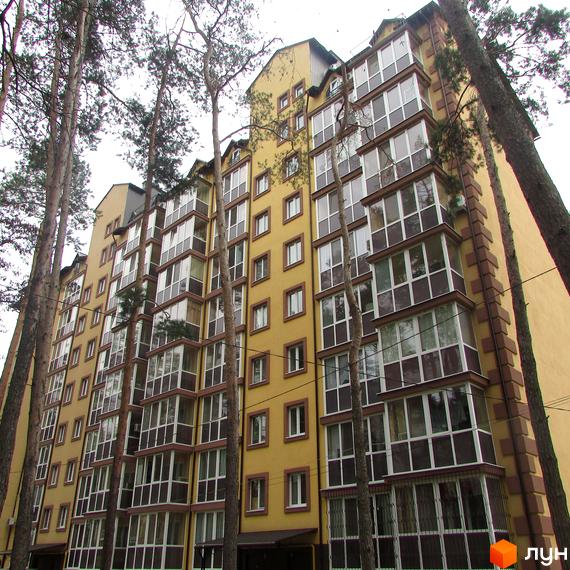 Житловий комплекс Полтавський двір. Висотна будівля з великою кількістю вікон та балконів, пофарбована в жовтий колір. Навколо будинку ростуть високі дерева.