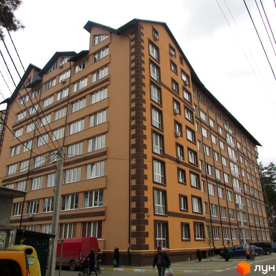 Багатоповерховий будинок ЖК Полтавський двір з великою кількістю вікон. На прибудинковій території є парковка та тротуар.