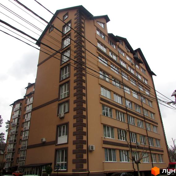 Житловий комплекс Полтавський двір. Висотна будівля з великою кількістю вікон, виконана у світлих тонах з темними декоративними елементами. Навколо будинку видно дерева та лінії електропередач.