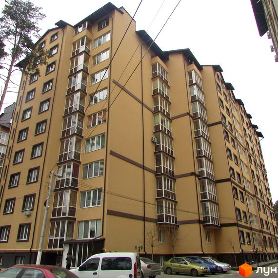 Висотна будівля ЖК Полтавський двір з великою кількістю вікон. На прибудинковій території розташовані паркувальні місця для автомобілів.