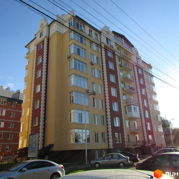 Висотна будівля ЖК Екофлетс з великими вікнами та балконами. На передньому плані припарковані автомобілі.