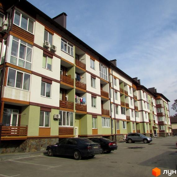 Зовнішній вигляд багатоповерхового будинку Житловий комплекс Європейський з балконами та парковкою. На території комплексу є паркувальні місця для автомобілів.