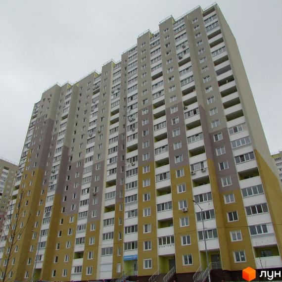 Висотна будівля житлового комплексу Ярославичі з великою кількістю вікон та балконів. Фасад виконаний у світлих тонах з використанням різних відтінків.