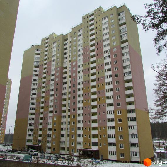 Висотна будівля ЖК Ярославичі з великою кількістю вікон та балконів. На прибудинковій території є парковка та дерева.