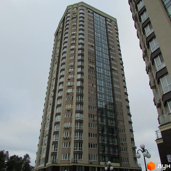 Високоповерховий житловий комплекс Зелений квартал з великою кількістю вікон та скляним фасадом. Будинок має багатоповерхову забудову з кондиціонерами на фасаді.