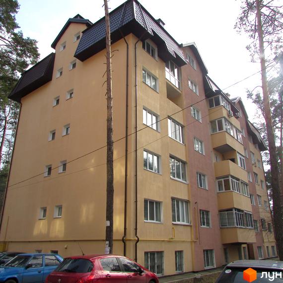 Житловий комплекс на вул. 10 Лінія, 17б, з фасадом у світлих тонах та балконами. Прибудинкова територія з автомобілями та деревами.