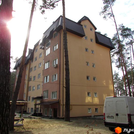 Будинок житлового комплексу вул. 10 Лінія, 17б з жовтою фасадною обробкою. Прибудинкова територія з деревами та зоною відпочинку.