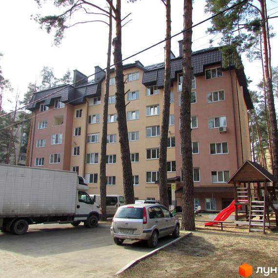 Житловий комплекс на вул. 10 Лінія, 17б. Багатоповерховий будинок з балконами та вікнами, поруч дитячий майданчик та припарковані автомобілі.