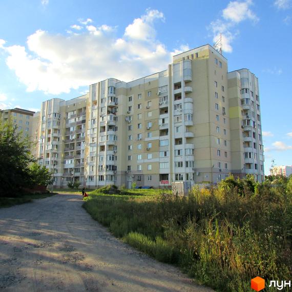 Житловий комплекс Уюткіно з багатоповерховим будинком та прибудинковою територією, оточений зеленню.