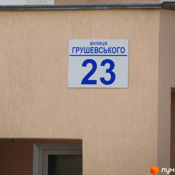 Будинок №23 по вулиці Грушевського з табличкою адреси. Зовнішній вигляд фасаду будівлі та частина входу.