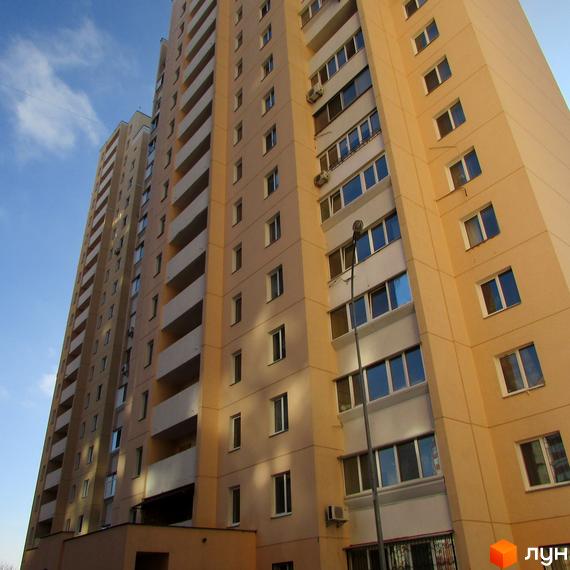 Фасад житлового комплексу на вул. Грушевського, 21а. Багатоповерхова будівля з балконами та вікнами.