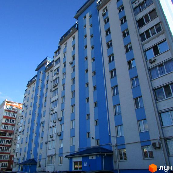 Зовнішній вигляд новобудови на вул. Грушевського, 17г. Багатоповерховий будинок з блакитно-білими фасадами та численними вікнами.