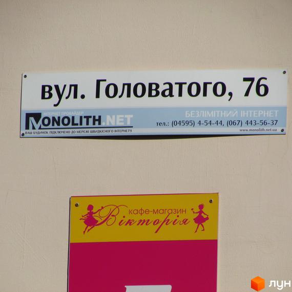 Вулична табличка з адресою вул. Головатого, 76. Нижче розташована вивіска кафе-магазину 