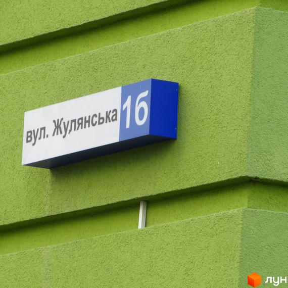 Назва вулиці Жулянська 16 на фасаді будинку. ЖК Евромісто - це новий житловий комплекс з сучасною архітектурою та розвиненою інфраструктурою.