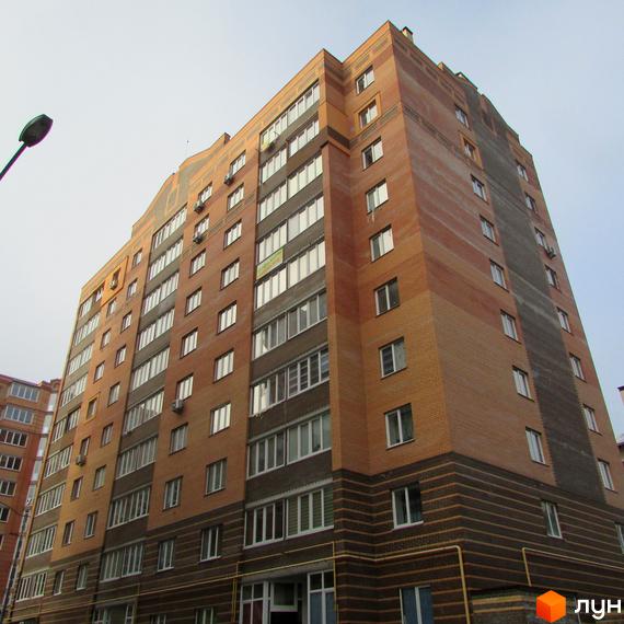 Житловий комплекс на вул. Лісова, 46, з цегляною фасадною обробкою та великими вікнами. Прибудинкова територія з зеленими насадженнями та освітленням.