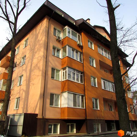 Зовнішній вигляд будинку на вул. Українська, 85в з балконами та великими вікнами. Прибудинкова територія з зеленими насадженнями.