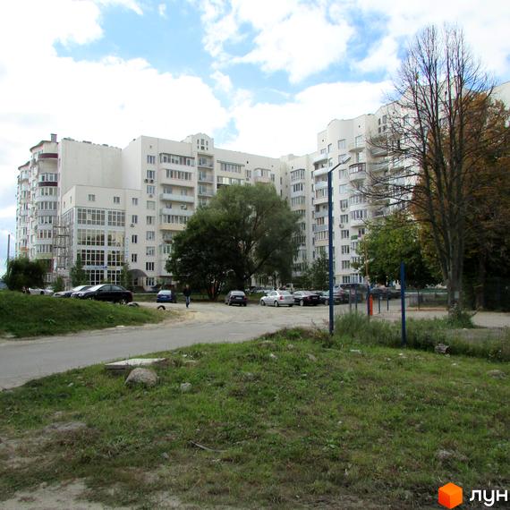 Житловий комплекс на вул. Старокиївська (Ватутіна), 99. Світлий багатоповерховий будинок з балконами та скляними фасадами, поруч дерева та парковка.