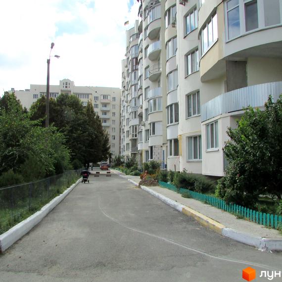 Житловий комплекс на вул. Старокиївська, 99. Вид на будинок з прибудинковою територією та зеленими насадженнями.