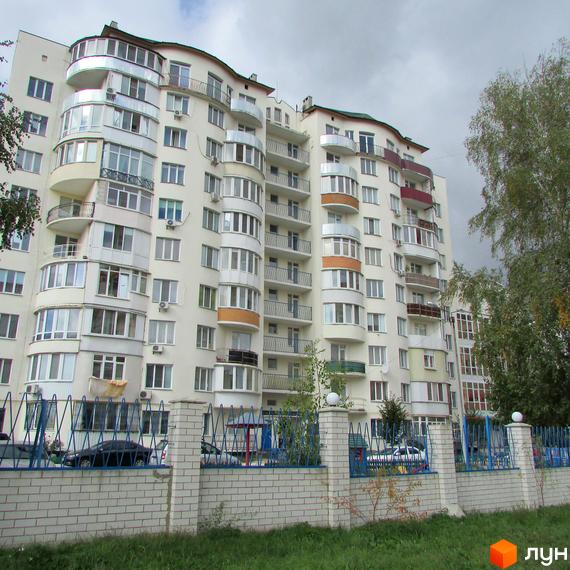 Житловий комплекс на вул. Старокиївська, 99 з балконами та прибудинковою територією, огородженою парканом.