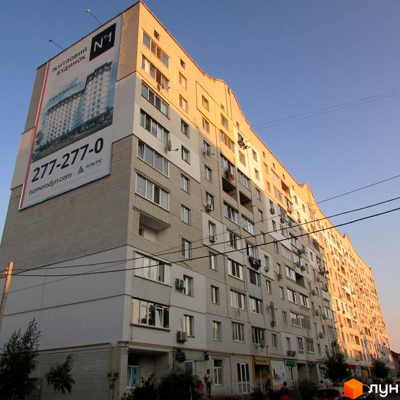 Житловий комплекс на вул. Головатого, 20 з фасадом та балконами. Прибудинкова територія з зеленими насадженнями та комерційними приміщеннями.