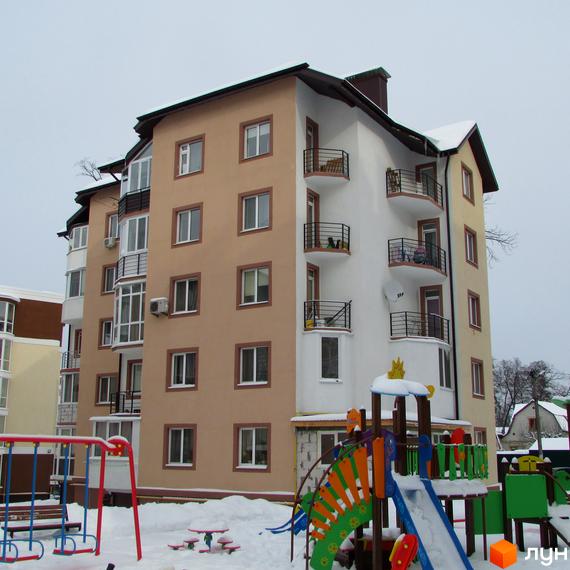 Житловий комплекс Джерело: багатоповерховий будинок з балконами та дитячий майданчик на фоні зимового пейзажу. Зовнішній вигляд будівлі та прибудинкова територія.