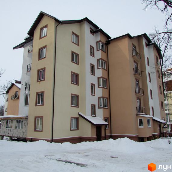 Зовнішній вигляд багатоповерхового будинку житлового комплексу Джерело взимку. Навколо будинку засніжена територія.