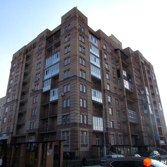 Житловий комплекс на вул. Шевченка, 4 з фасадом з великими вікнами та прибудинковою територією.