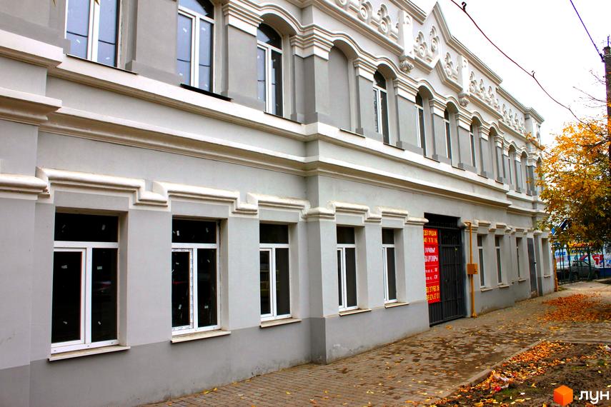 Фасад житлового комплексу на вулиці Отамана Головатого, 24, з архітектурними елементами та вікнами. Поруч розташована бруківка з опалим листям.