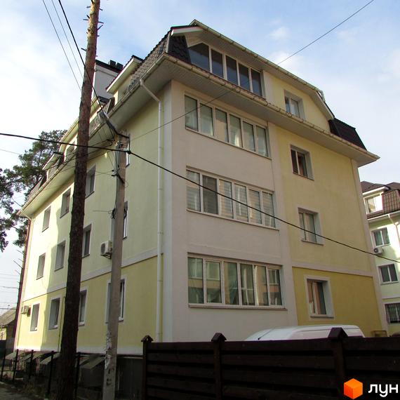 Житловий комплекс на вул. 10 Лінія, 4а, з жовтою фасадною частиною та великими вікнами, огороджений парканом.