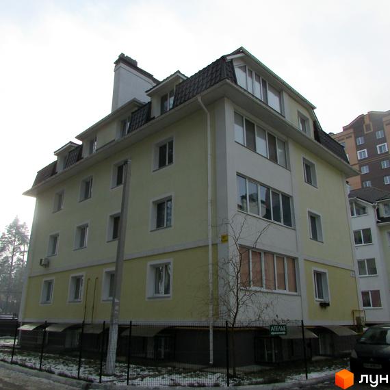 Житловий комплекс на вул. Лісова, 6, з жовтою фасадною частиною та прибудинковою територією. Вид на будинок з боку двору.