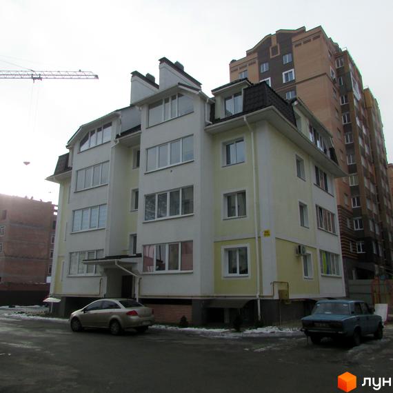 Зовнішній вигляд будинку на вул. Лісова, 6 з великими вікнами та прибудинковою територією. Вид на автомобілі біля входу.