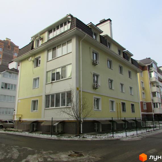 Житловий комплекс на вул. Лісова, 6 з жовтою фасадною частиною та прибудинковою територією. Вид на будинок з боку дороги.