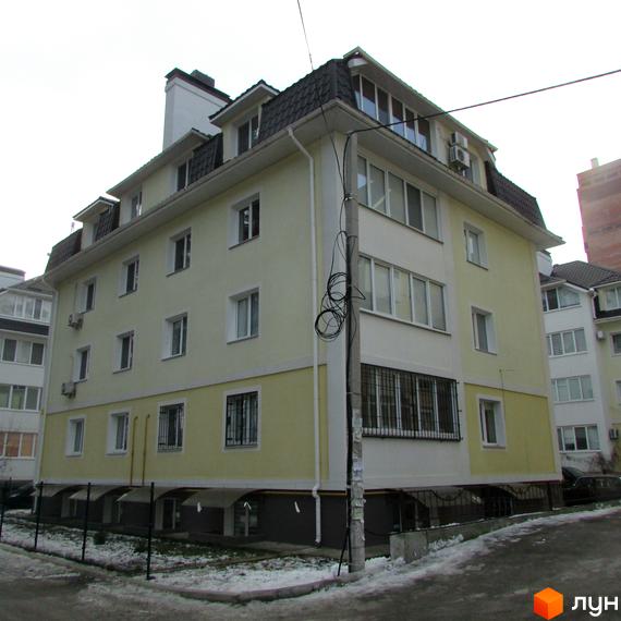 Житловий комплекс на вул. Лісова, 6, з фасадом жовтого та білого кольору. Прибудинкова територія з невеликим газоном та паркомісцями.