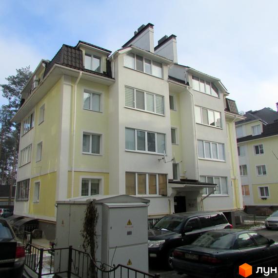 Житловий комплекс на вул. Лісова, 6 з жовтою фасадною обробкою. Прибудинкова територія з автомобілями та зеленими насадженнями.