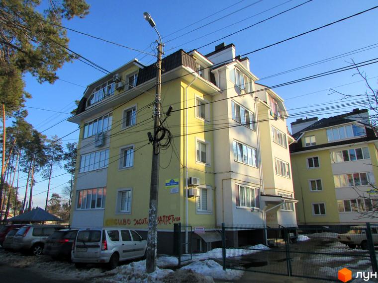 Житловий комплекс на вул. Літературна, 1, з жовтою фасадною частиною та прибудинковою територією з автомобілями.