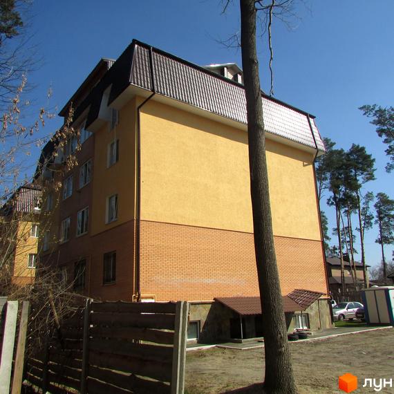 Житловий комплекс на вул. Полтавська, 31к з жовтою фасадною стіною та прибудинковою територією, оточений деревами.