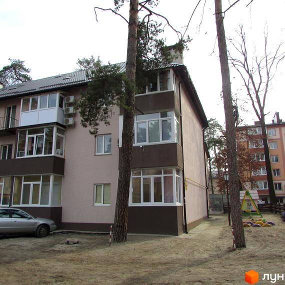 Житловий комплекс на вул. Варшавська, 95, з фасадом з вікнами та прибудинковою територією з дитячим майданчиком.