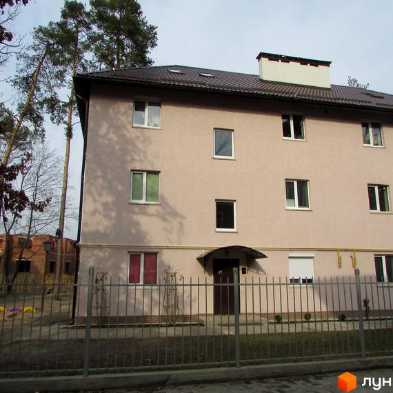 Житловий комплекс на вул. Варшавська, 95, має світлу фасадну частину з вікнами. Прибудинкова територія озеленена та огороджена.