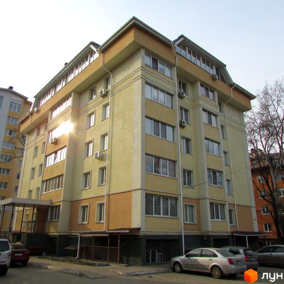 Житловий комплекс на вул. Мінеральна, 37, з жовтою фасадною обробкою та прибудинковою територією, що включає парковку.