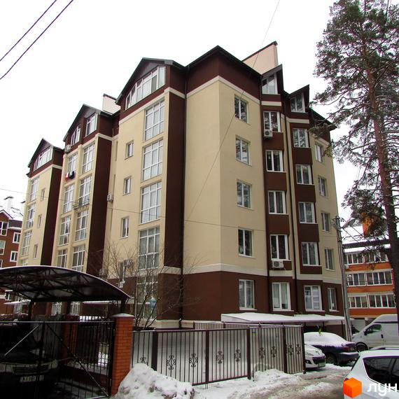 Житловий комплекс на вул. Пушкінська, 62е, з фасадом у світлих тонах та прибудинковою територією, засніженою взимку.