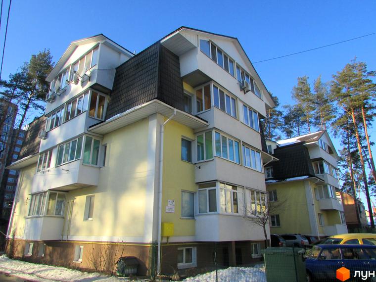 Зовнішній вигляд будинку на вул. Літературна, 6 з великими вікнами. Прибудинкова територія з автомобілями та зеленими насадженнями.