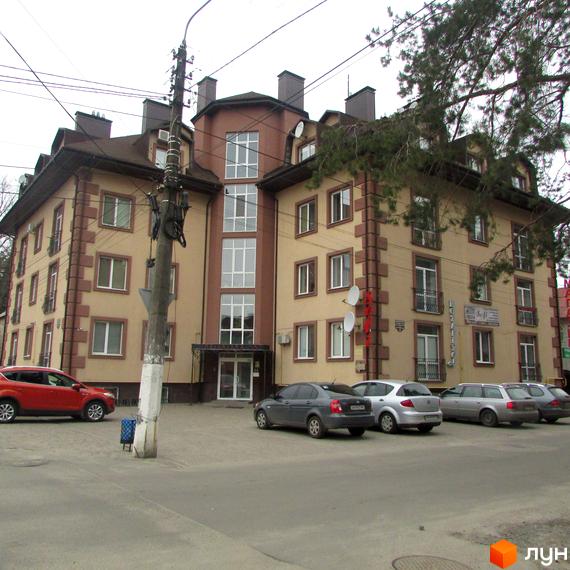 Житловий комплекс на вул. Полтавська, 45. Вид на фасад будинку та прибудинкову територію з автомобілями.