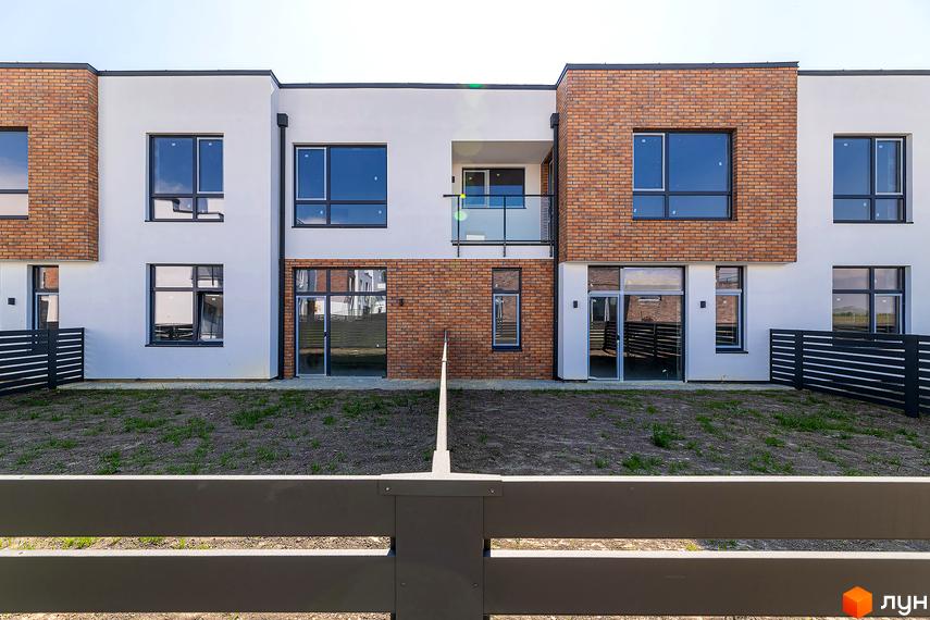 Котеджне містечко КМ Липові Роси: фасади будинків з цегляними та білими елементами, великі вікна, скляний балкон. Прибудинкова територія з газоном та парканом.